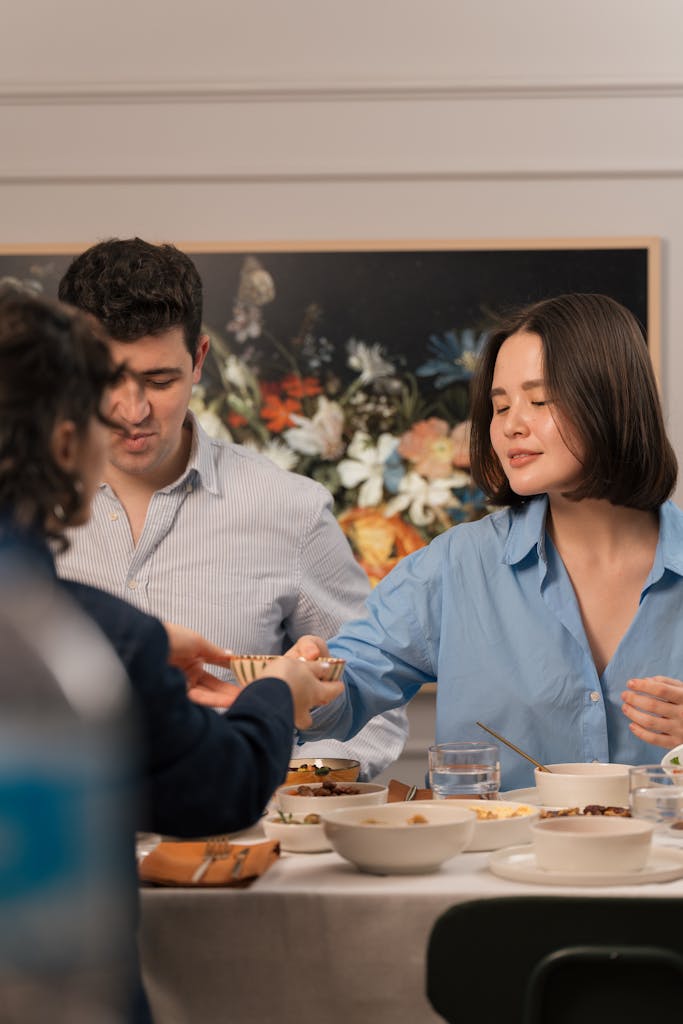 A group of adults enjoying a meal together at a dining table indoors.